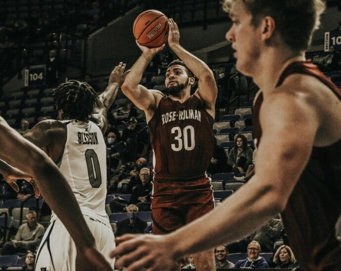 Basketball players in an intense college game action, showcasing skill on court.