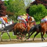 Dynamic horse racing scene with jockeys and vibrant nature backdrop.
