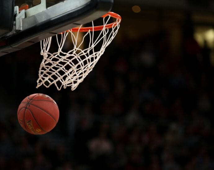 A basketball going through the hoop during a fast-paced game, capturing the excitement of the sport.