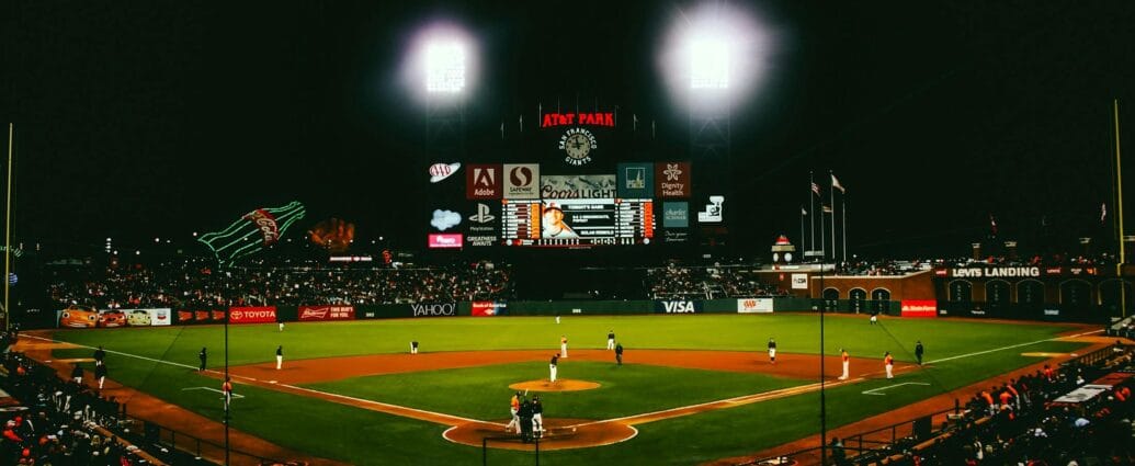 Exciting evening baseball game with fans at AT&T Park stadium under bright lights.