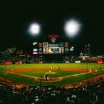 Exciting evening baseball game with fans at AT&T Park stadium under bright lights.