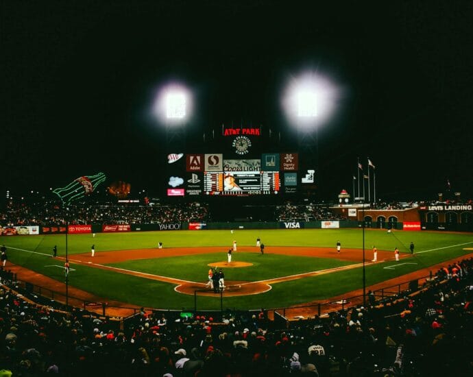 Exciting evening baseball game with fans at AT&T Park stadium under bright lights.