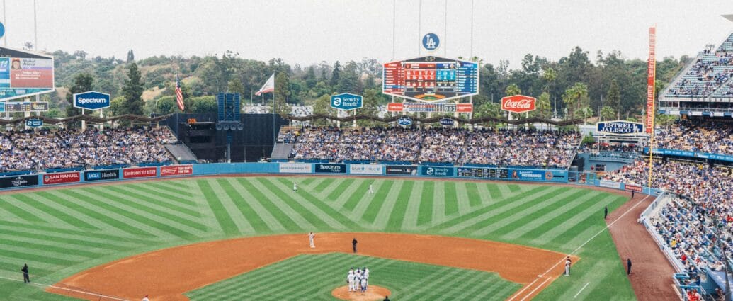 Vibrant baseball game at Dodger Stadium with packed stands and players on the field.