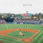Vibrant baseball game at Dodger Stadium with packed stands and players on the field.
