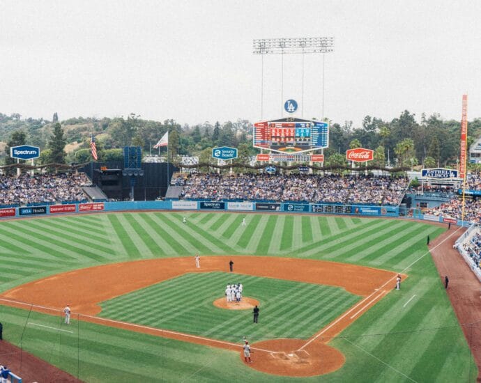 Vibrant baseball game at Dodger Stadium with packed stands and players on the field.