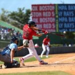 Action-packed baseball game in Santo Domingo, capturing a powerful swing.