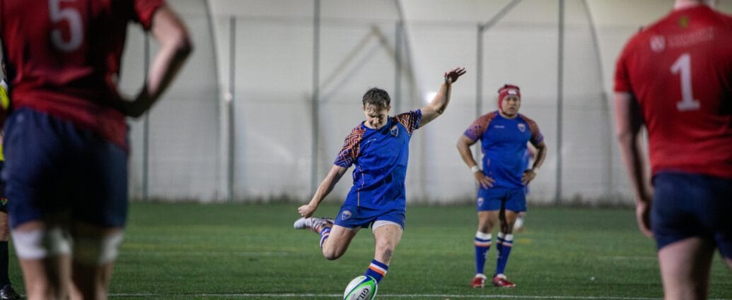 Dynamic rugby match in England with players in vibrant uniforms, showcasing teamwork and skill.