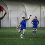 Dynamic rugby match in England with players in vibrant uniforms, showcasing teamwork and skill.