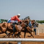 Dynamic horse race capturing several jockeys competing on a clear day.