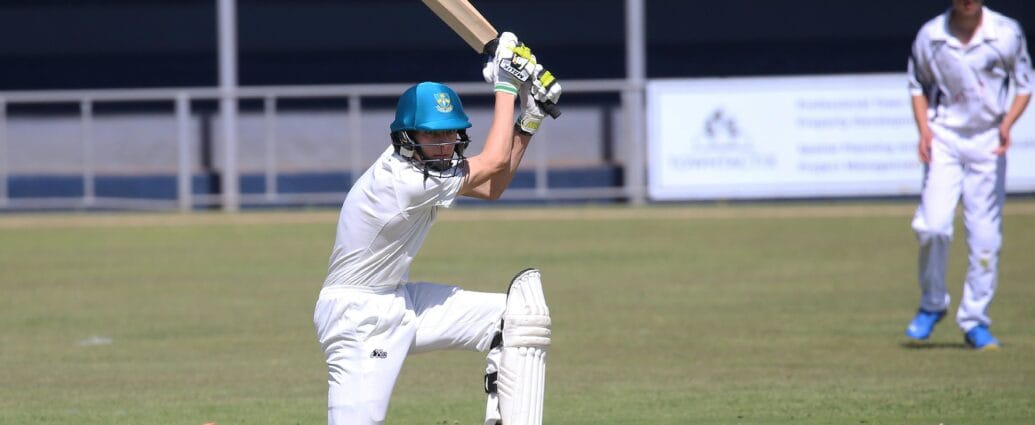 Two young cricketers playing a match, showcasing batting skills on the field.