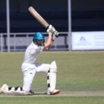 Two young cricketers playing a match, showcasing batting skills on the field.