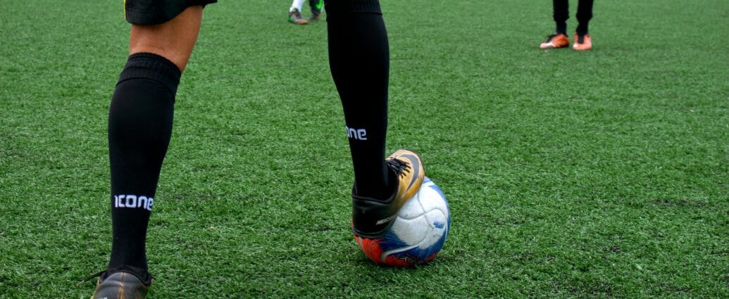 Close-up of a soccer player controlling the ball during a match on a green field.
