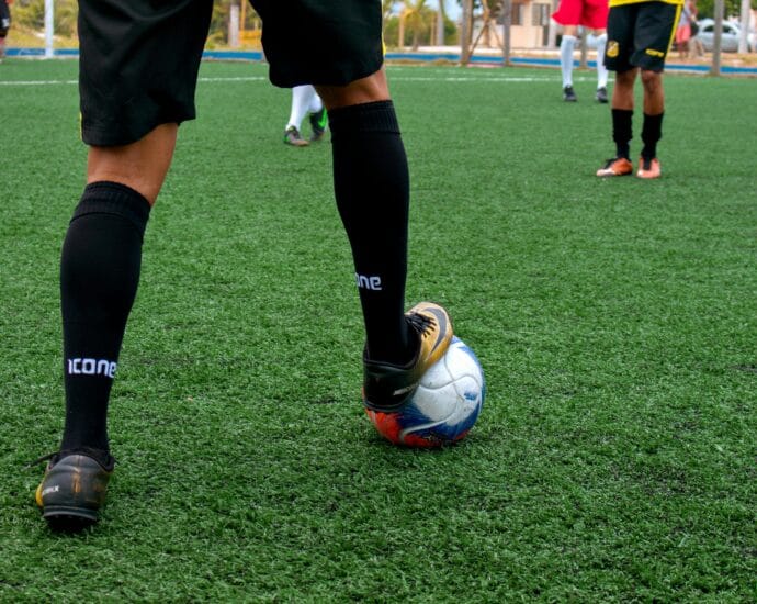 Close-up of a soccer player controlling the ball during a match on a green field.