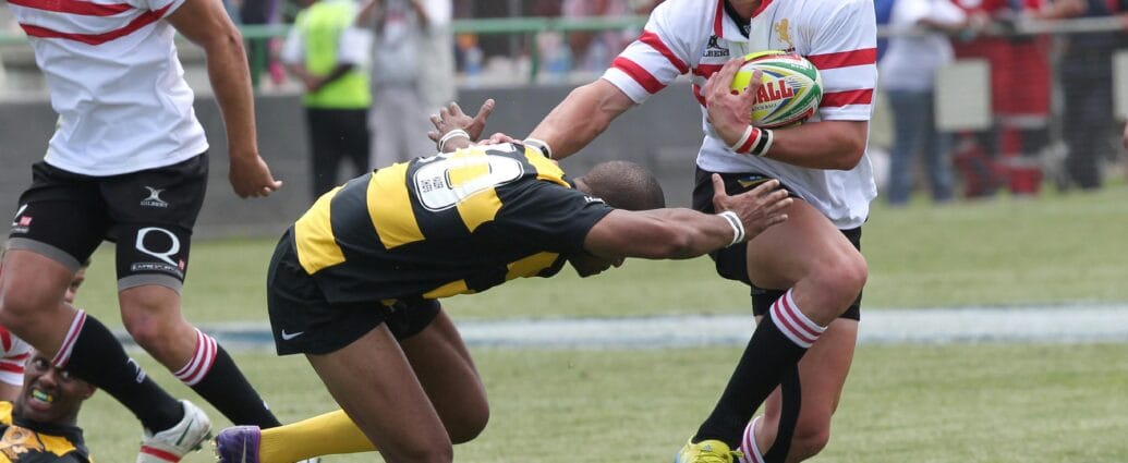 Action-packed rugby scene capturing a dramatic tackle during a competitive match.
