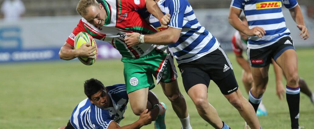 Dynamic action shot of rugby players in a fierce tackle during a lively outdoor game.