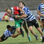 Dynamic action shot of rugby players in a fierce tackle during a lively outdoor game.