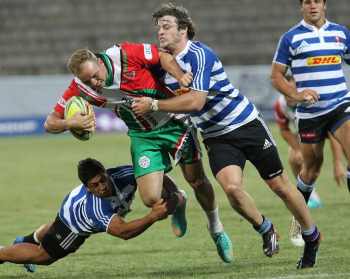Dynamic action shot of rugby players in a fierce tackle during a lively outdoor game.