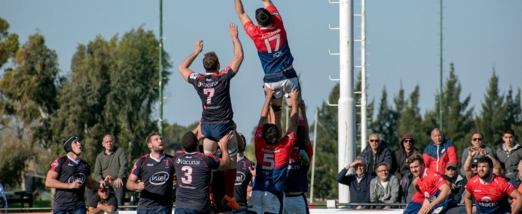 Rugby players competing midair in a dynamic outdoor match in Buenos Aires, Argentina.