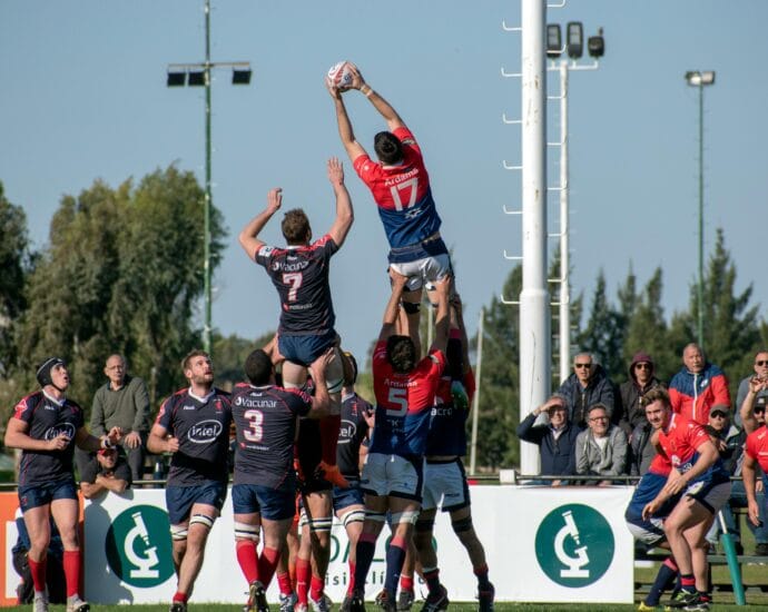 Rugby players competing midair in a dynamic outdoor match in Buenos Aires, Argentina.
