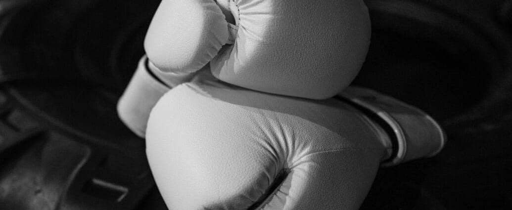 Elegant monochrome close-up of white boxing gloves symbolizing strength and courage.