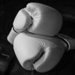 Elegant monochrome close-up of white boxing gloves symbolizing strength and courage.