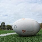 A detailed shot of a rugby ball on a green sports field, perfect for sports equipment themes.
