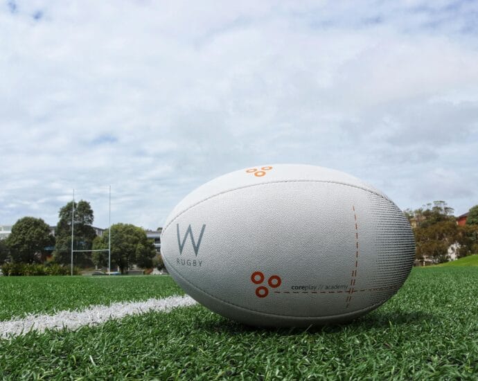A detailed shot of a rugby ball on a green sports field, perfect for sports equipment themes.
