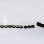 A row of hockey pucks and a stick on an ice rink, perfect for sports content.