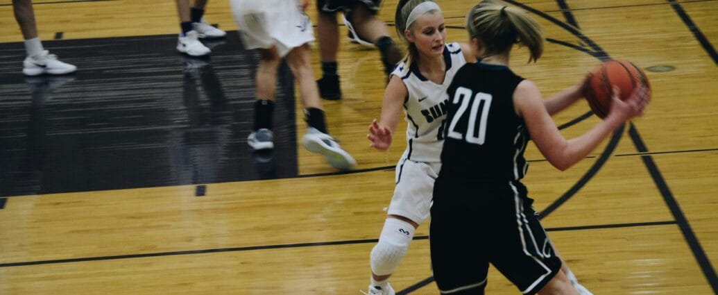 Dynamic shot of a women's basketball game with players in action on the court.