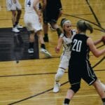 Dynamic shot of a women's basketball game with players in action on the court.