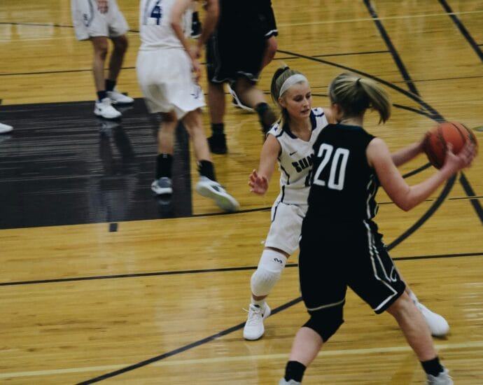 Dynamic shot of a women's basketball game with players in action on the court.