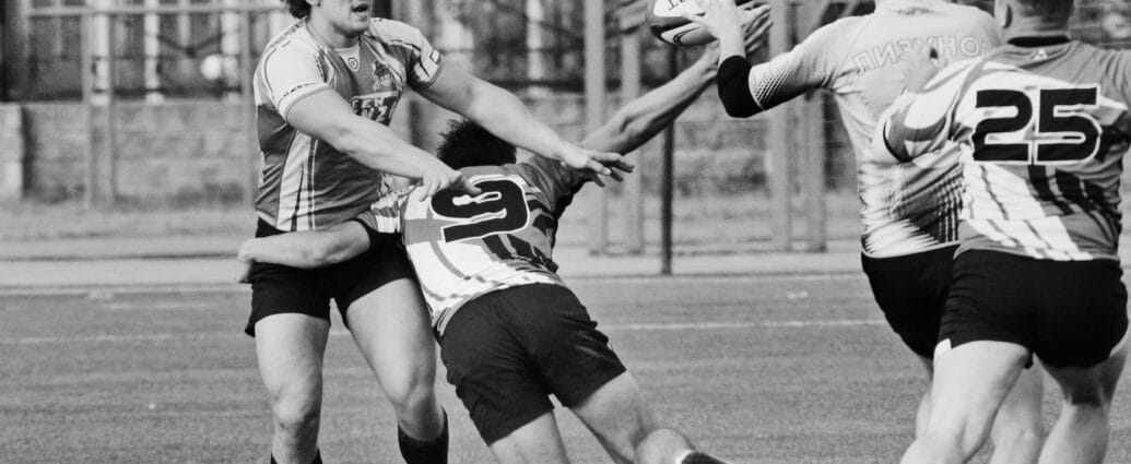 Dynamic black and white photo of rugby players in action during an intense match on the field.
