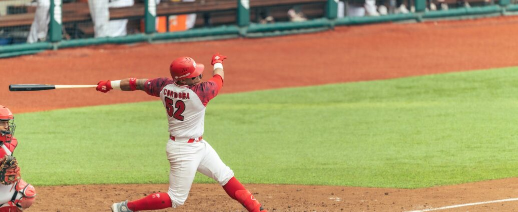 A baseball player powerfully swings the bat during a game, capturing the essence of competitive sports.