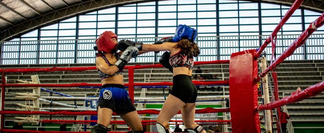 Dynamic kickboxing match between two women in a stadium ring.