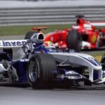 Close-up of two Formula 1 cars racing at high speed during a championship event.