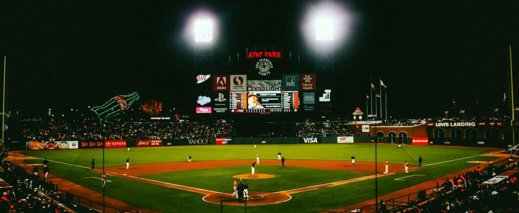Exciting evening baseball game with fans at AT&T Park stadium under bright lights.