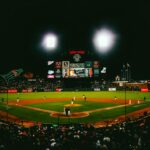 Exciting evening baseball game with fans at AT&T Park stadium under bright lights.