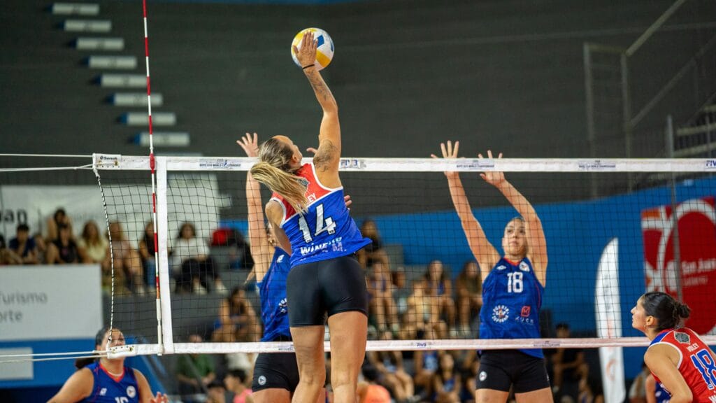 Dynamic women’s indoor volleyball action showcasing a spike during a competitive match.